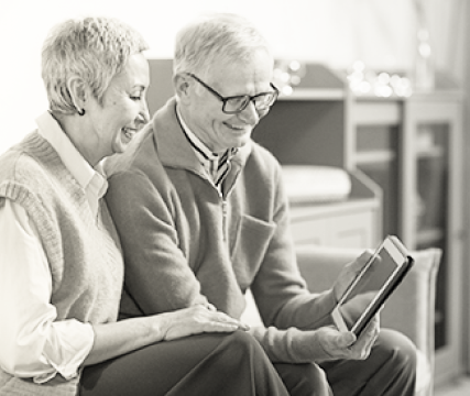 grandfather & grandmother looking at a tablet